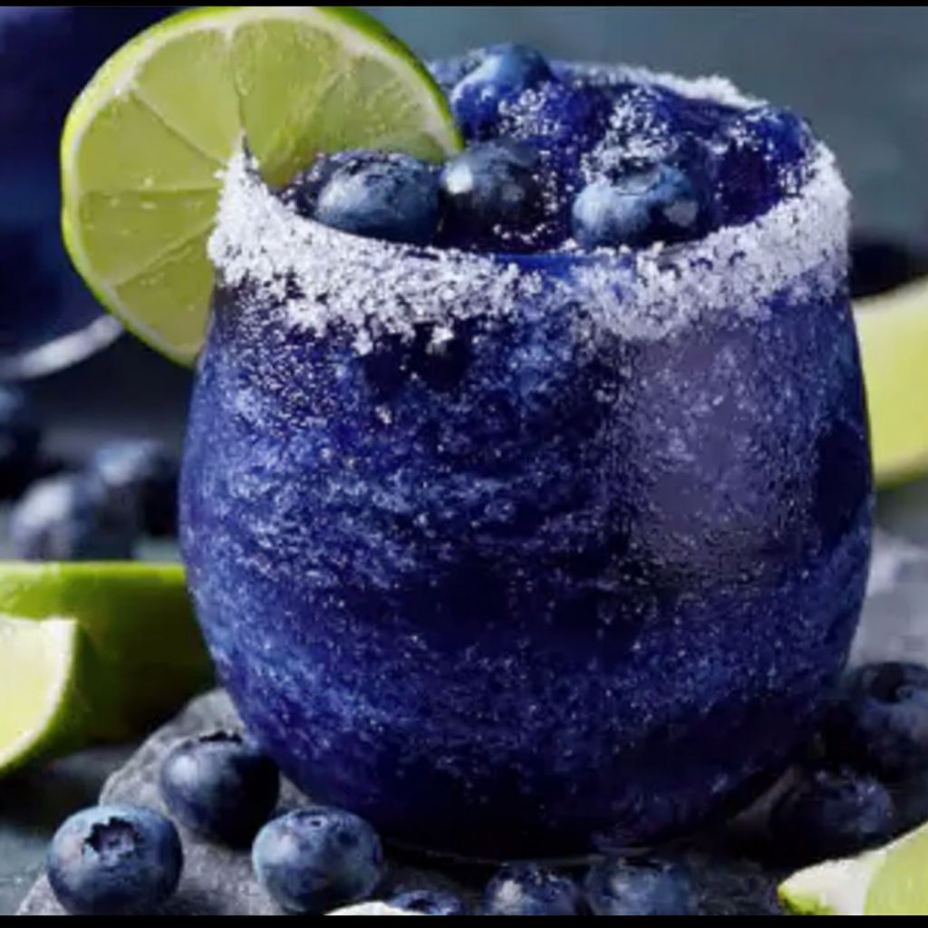 A blue frozen margarita with blueberries and lime.