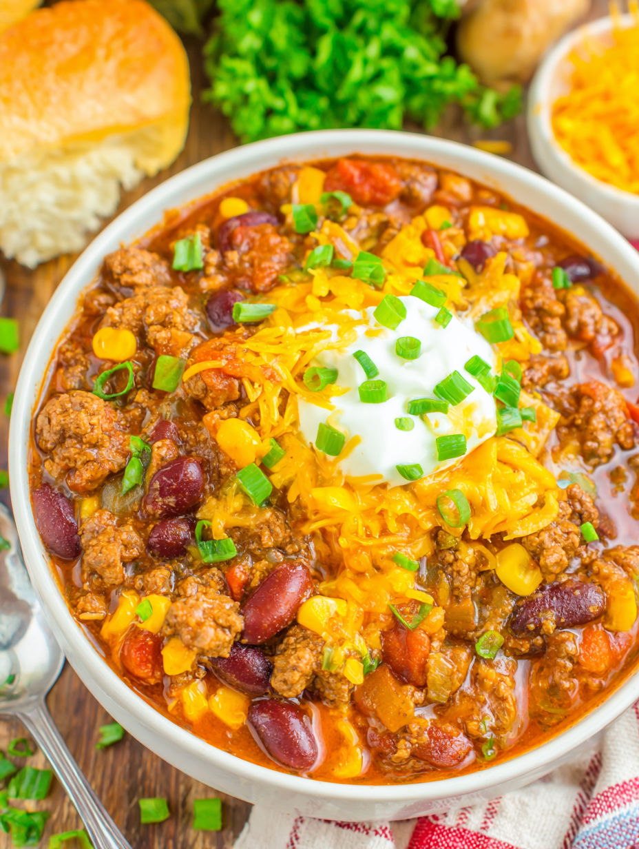 A bowl of chili with a dollop of sour cream on top.