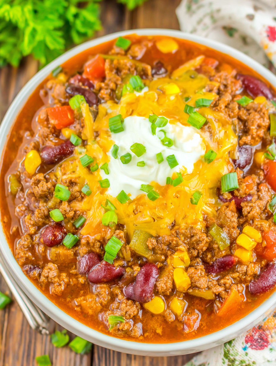 A bowl of chili with a dollop of sour cream on top.