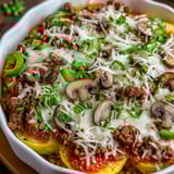 A bowl of food with mushrooms and cheese.