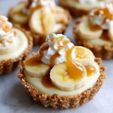 A close up of a banana cream pie with whipped cream on top.