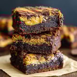 A stack of brownies with a cookie crust.