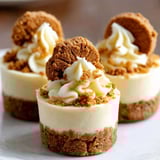 Three mini biscoff cheesecake cups with white whipped cream.