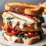 A sandwich with bacon and cheddar cheese.