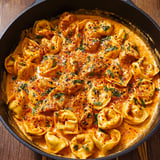 A bowl of pasta with a spicy garlic butter sauce.