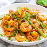 A white bowl filled with shrimp and vegetables.