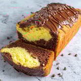 A slice of chocolate cake with chocolate drizzled on top.