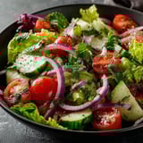 A bowl of crispy garden salad with vinaigrette.