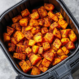 A black container filled with sliced pumpkin.