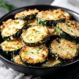 A bowl of baked Parmesan zucchini rounds.