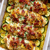 A dish of chicken and zucchini with bacon on top.