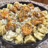 A bowl of pasta with chicken and cheese.