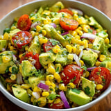 A bowl of avocado, tomato, and corn salad.