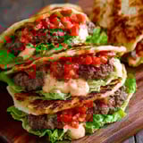 A quesadilla burger melt with tomatoes and lettuce.