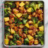 A pan of chicken, pineapple, and broccoli.