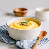 A bowl of creamy polenta with a spoon in it.