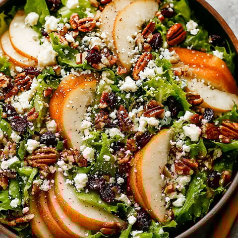 A bowl of salad with apples, nuts, and cheese.