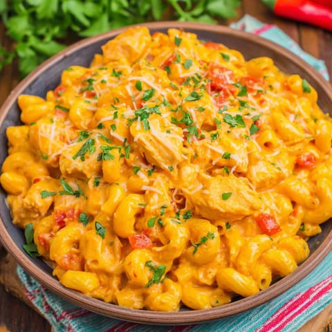 A bowl of food with chicken, tomatoes, and cheese.