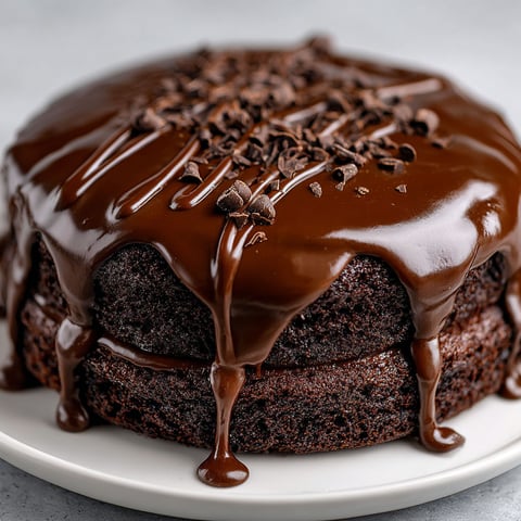 A chocolate cake with chocolate ganache drizzled on top.