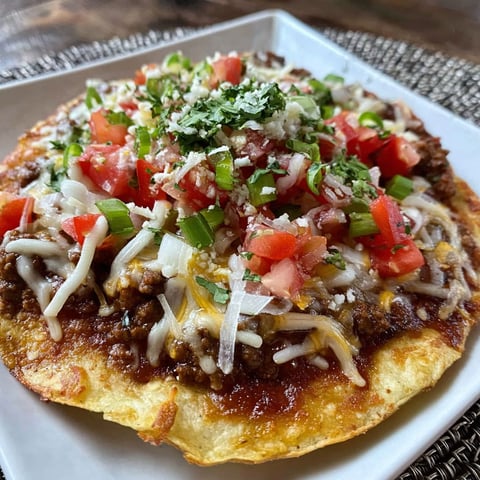 A plate of Mexican food with tomatoes, cheese, and chicken.